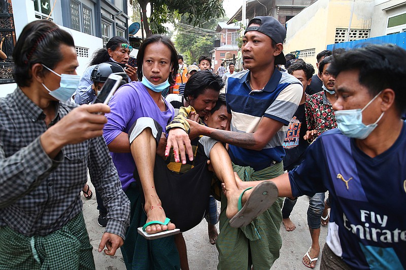 A man is carried after police dispersed protesters in Mandalay, Myanmar on Saturday, Feb. 20, 2021. Security forces in Myanmar ratcheted up their pressure against anti-coup protesters Saturday, using water cannons, tear gas, slingshots and rubber bullets against demonstrators and striking dock workers in Mandalay, the nation's second-largest city. (AP Photos)