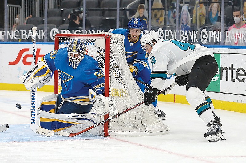 Tomas Hertl of the Sharks tries to get the puck past Blues goalie Jordan Binnington during the third period of Saturday's game in St. Louis.