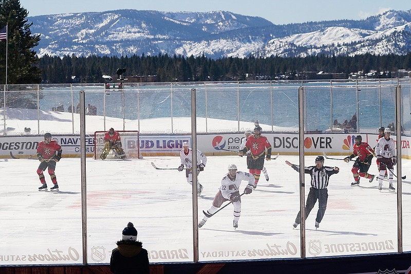 Members of the Colorado Avalanche, in white, and the Vegas Golden Knights, red play during the first period of the Outdoor Lake Tahoe NHL hockey game in Stateline, Nev., Saturday, Feb. 20, 2021. (AP Photo/Rich Pedroncelli))