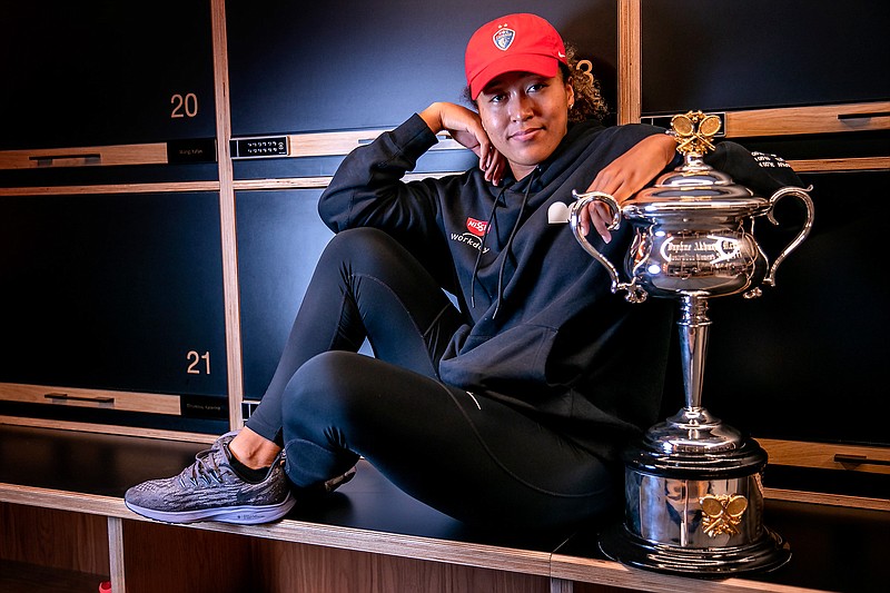 Japan's Naomi Osaka poses with the Daphne Akhurst Memorial Cup in the locker room in the early hours of Sunday Feb. 21, 2021 after defeating United States Jennifer Brady in the women's singles final at the Australian Open tennis championship in Melbourne, Australia, Saturday, Feb. 20, 2021.(Fiona Hamilton/Tennis Australia via AP)