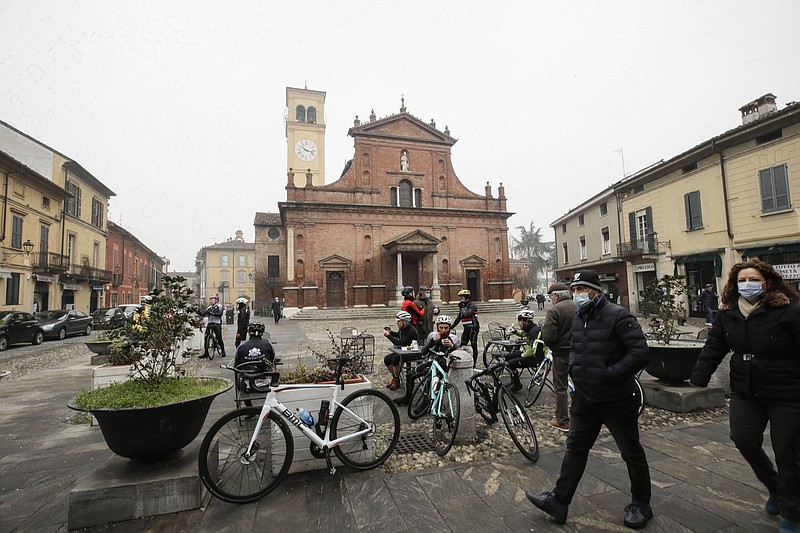 People and cyclists relax in front of the San Biagio church in Codogno, northern Italy, Sunday, Feb. 21, 2021. The first case of locally spread COVID-19 in Europe was found in the small town of Codogno, Italy one year ago on February 21st, 2020. The next day the area became a red zone, locked down and cutoff from the rest of Italy with soldiers standing at roadblocks keeping anyone from entering of leaving. (AP Photo/Luca Bruno)