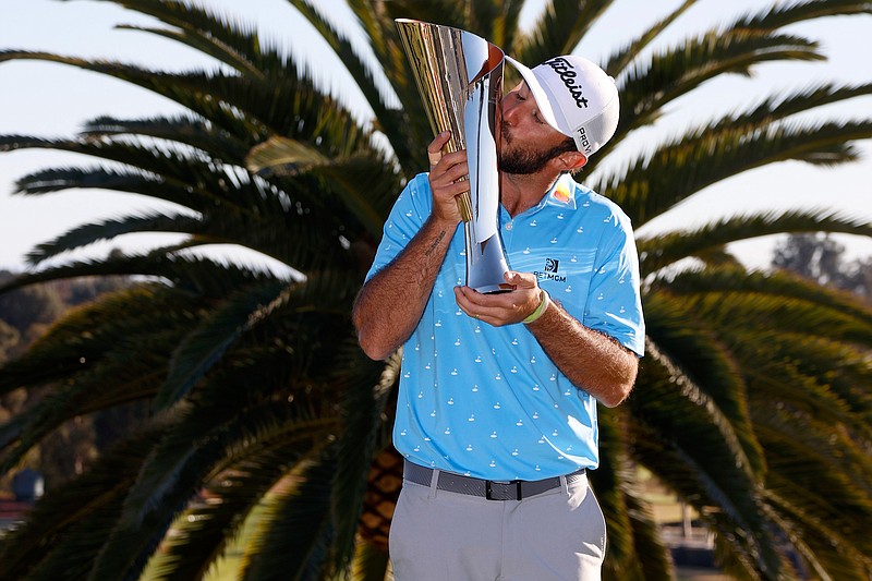 Max Homa kisses his trophy on the practice green after winning the Genesis Invitational golf tournament at Riviera Country Club, Sunday, Feb. 21, 2021, in the Pacific Palisades area of Los Angeles. (AP Photo/Ryan Kang)
