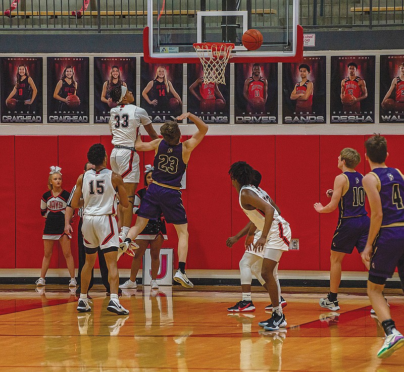 Michael Onunkwor of Jefferson City rejects a shot by Troy's Jacob Bruns during Monday night's game at Fleming Fieldhouse.  