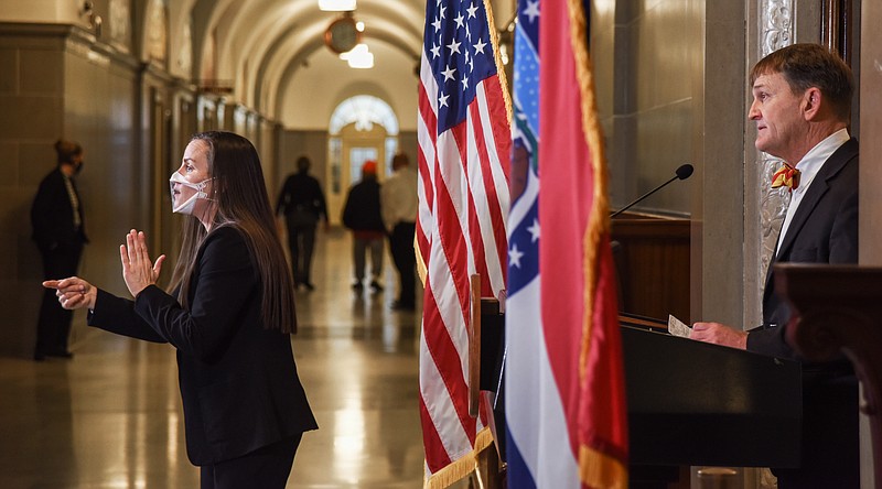 Brown performs interpretive services during the news conference where Dr. Randall Williams addressed reporters.