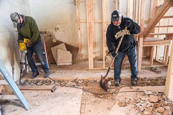 Dave Kaplan, right, shovels out concrete after Jim Matteson chips away at the solid material in the basement floor of the Transformational Housing house at 203 Cherry St. They are just two of the numerous volunteers that have been working on the ongoing project.