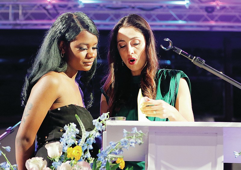 <p>News Tribune file</p><p>Rebecca Welsh, right, goes over the evening itinerary with Marjai at the HALO Foundation’s annual ArtReach Auction at the Capital Bluffs Event Center in 2020. Due to public health concerns, this year’s event will be held virtually Friday.</p>