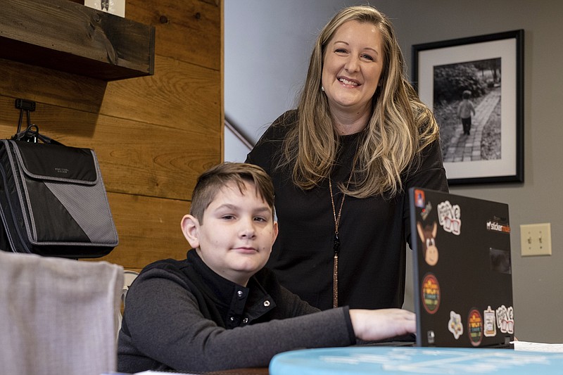 Kelli Rivera is photographed with her son Tate, 11 at their home in Roswell, Ga., Friday, Feb. 12, 2021.  Rivera is hoping a voucher bill passes that will help pay for her to move her son out of a public Cobb County school and into a private school.  (AP Photo/Ben Gray)
