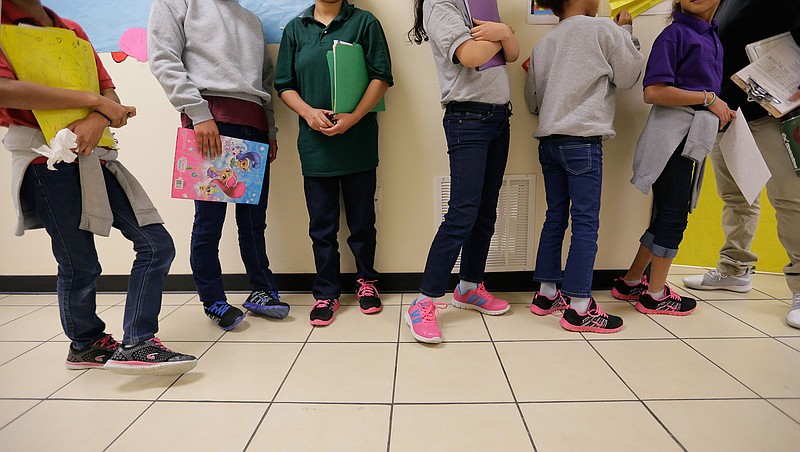 In this Aug. 29, 2019, file photo, migrant teens line up for a class at a "tender-age" facility for babies, children and teens, in Texas' Rio Grande Valley, in San Benito, Texas. With its long-term facilities for immigrant children nearly full, the Biden administration is working to expedite the release of children to their relatives in the U.S. The U.S. Health and Human Services on Wednesday, Feb. 24, 2021, authorized operators of long-term facilities to pay for some of the children's flights and transportation to the homes of their sponsors. (AP Photo/Eric Gay File)