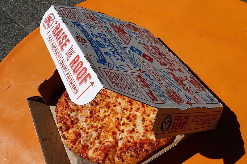 This July 15, 2019, file photo shows a small Domino's pizza made in a Domino's Pizza shop in downtown Pittsburgh.  After a pandemic-fueled boom, U.S. pizza sales appear to be headed back to Earth. Domino's and Papa John's pizza chains both said Thursday, Feb. 25, 2021,  that their same-store sales lost steam in the fourth quarter compared to the huge increases they saw earlier in 2020.    (AP Photo/Gene J. Puskar, File)