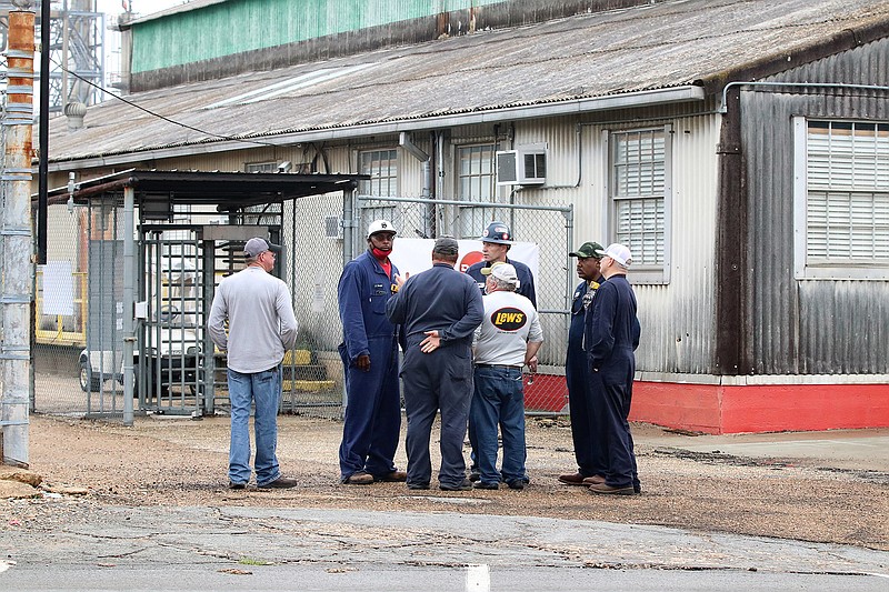 Workers stand together Saturday after a fire broke out at Delek: El Dorado Refinery, formerly known as Lion Oil, in El Dorado, Ark. Seven people were injured, El Dorado Fire Chief Chad Mosby said. (Photo courtesy of Penny Chanler)

