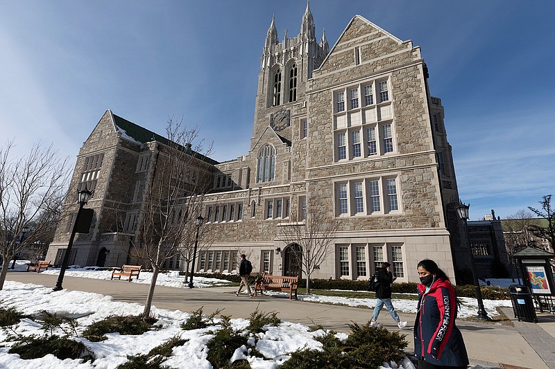 Students walk on the Boston College campus Feb. 17 in Boston. President Joe Biden campaigned on multiple tuition-free college proposals. But experts are divided on whether now is the time students could see a broad free college program. 