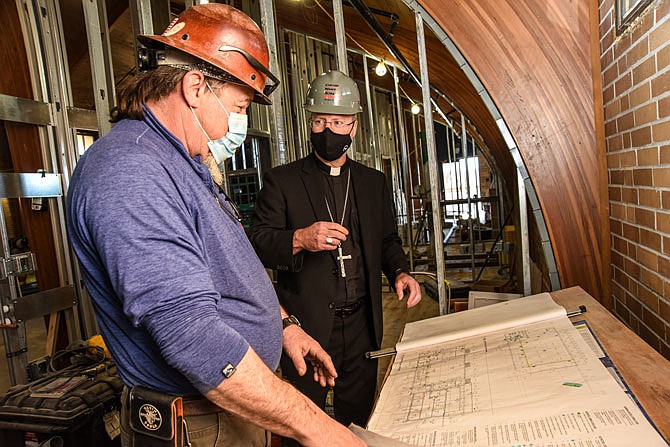 Bishop W. Shawn McKnight and Doug Shrader, near, look over the plans Tuesday for Catholic Charities of Central and Northern Missouri's new location. Shrader, who is superintendent for Curtis Manes Schulte, contractor on the project, took McKnight and others on a tour of the new facility located in Shikles Center. CCCNM purchased Shikles Center from the Jefferson City Housing Authority and began renovation of it last year. Areas of the building will include rooms for medical use, open area for gatherings, meetings, tutoring, etc., a chapel and office space. In addition, room is being added on the lower level for bulk food storage where individuals will be able to select food items much like in a grocery store.