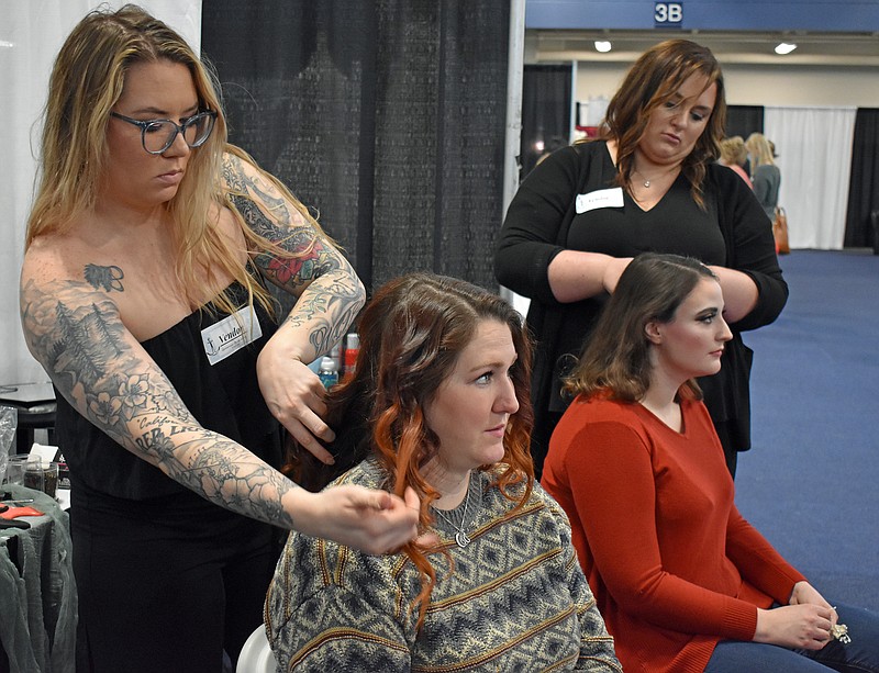 Gerry Tritz/News TribuneAt left, Morgan Boyles of Broadway Hair Co. works on Natalie Eickhoff, while Broadway Hair's Angela McFarland works on Emma Tracy during Sunday's Bridal Show at The Linc.