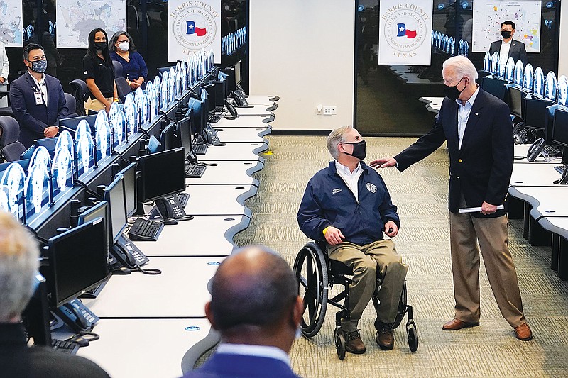  President Joe Biden talks with Texas Gov. Greg Abbott as they tour the Harris County Emergency Operations Center Friday in Houston.
