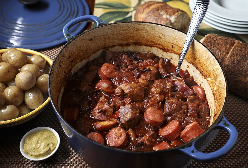Pork simmers in a Dutch oven or slow cooker with cabbage and sauerkraut. Kielbasa is added near the end of cooking. (Abel Uribe/Chicago Tribune/TNS)