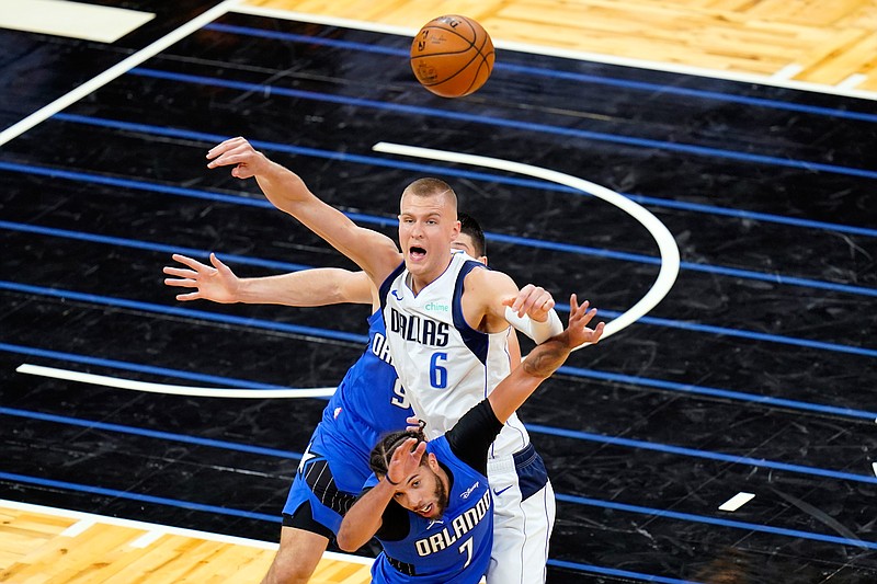 Orlando Magic guard Michael Carter-Williams (7) knocks the ball out of the hands of Dallas Mavericks center Kristaps Porzingis (6) during the second half of an NBA basketball game, Monday, March 1, 2021, in Orlando, Fla. (AP Photo/John Raoux)