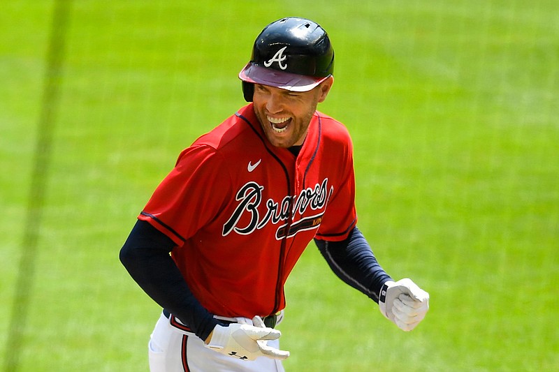 Atlanta Braves' Freddie Freeman reacts as he runs along the third base line after hitting a grand slam home run in the sixth inning of a baseball game against the Washington Nationals in Atlanta, in this Sunday, Sept. 6, 2020, file photo. NL MVP Freddie Freeman has followed his big season with the Atlanta Braves with an even more memorable offseason. He and his wife have two baby boys, including one from a surrogate mother. He calls his new babies his "twins with a twist."(AP Photo/John Amis, File)
