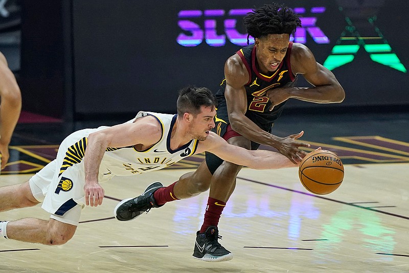 Indiana Pacers' T.J. McConnell, left, and Cleveland Cavaliers' Collin Sexton reach for the ball during the first half of an NBA basketball game Wednesday, March 3, 2021, in Cleveland. (AP Photo/Tony Dejak)