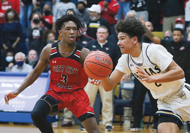 Desmond White of Helias tries to dribble past Aaron Stallings of Jefferson City in the final seconds of Friday night's Class 6 District 9 title game at Rackers Fieldhouse. 