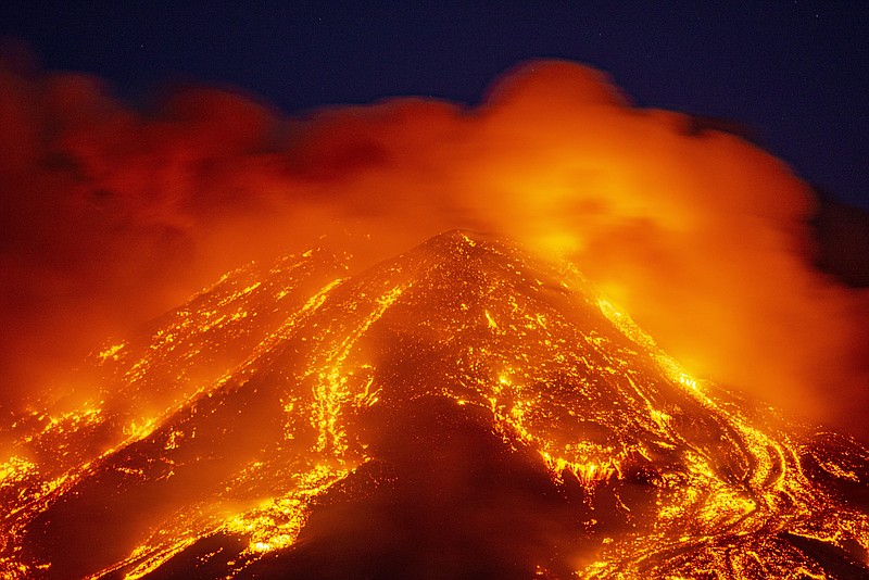 FILE - In this Tuesday, Feb. 16, 2021 file photo, lava gushes from the Mt. Etna volcano near Catania, southern Italy. The spectacular explosions of Mount Etna are continuing Sunday, March 7, 2021, with the volcano in eastern Sicily, spewing out towering clouds of ash and lava stones. Italy’s national geophysics and volcanology institute said the latest big explosion occurred hours before dawn on Sunday, with the volcano exhibiting increasing tremors throughout the night. (AP Photo/Salvatore Allegra, File)