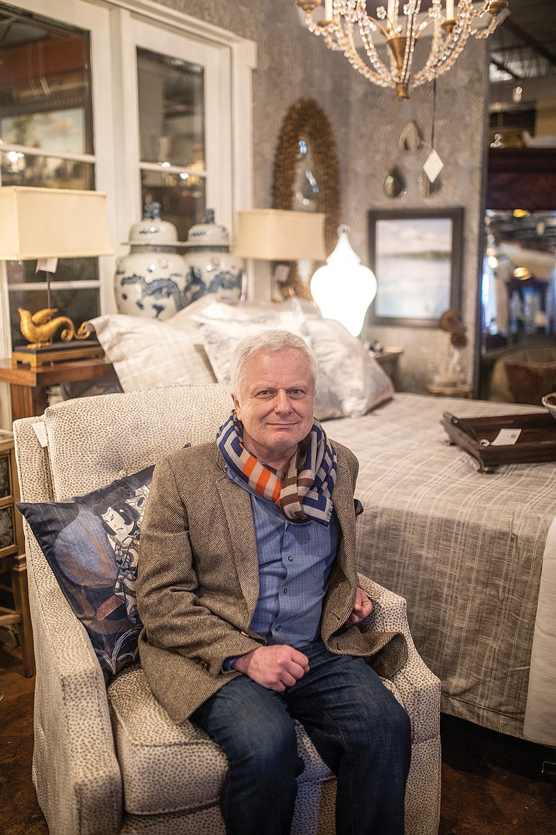 Jeff Brown, owner of JBrown For the Home, sits in a bedroom setup in his store.
