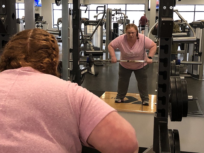 <p>Ryan Boland/FULTON SUN</p><p style="text-align:right;">Chris Buchholz, of Fulton, examines her technique in the mirror Thursday afternoon while lifting weights in the YMCA of Callaway County’s new fitness room. The YMCA will reveal the expansion and renovation of its facilities to the public during an open house from 9 a.m.-noon March 26. There will also be a ribbon-cutting ceremony at 10:30 a.m.</p>