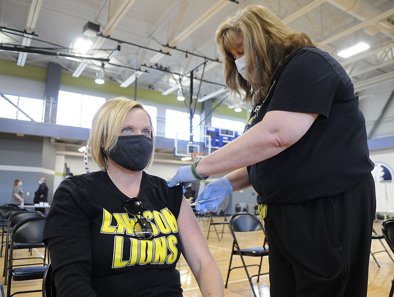 Jennifer Uptergrove, first-grade teacher at Lawson Elementary School in Jefferson City, receives the first dose of the COVID-19 vaccine Friday, March 19, 2021, inside The Linc. 