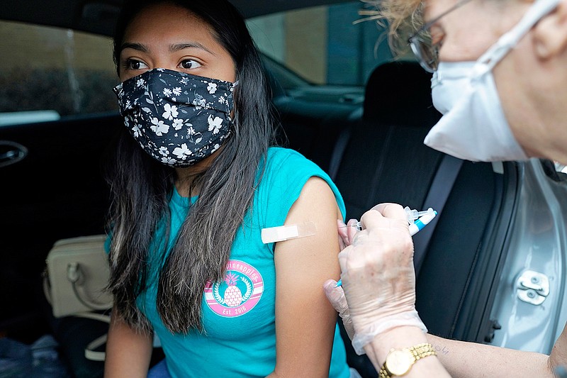 Jennifer Lira, left, a childcare specialist in the Spring Branch Independent School District, receives a Pfizer COVID-19 vaccination shot from nurse Carolyn Roy during a vaccination drive for education workers Tuesday, March 16, 2021, in Houston. (AP Photo/David J. Phillip)