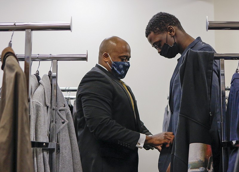 Liv Paggiarino/News Tribune

Earnest Washington, LU Director of Campus Wellness and Recreation, helps LU student Aaron Spencer try on a suit jacket on Wednesday at the Blue Tigers Resource Center. Washington and other faculty members helped a number of students pick out suits that fit them well, and gave advice on how to find a good-fitting suit.