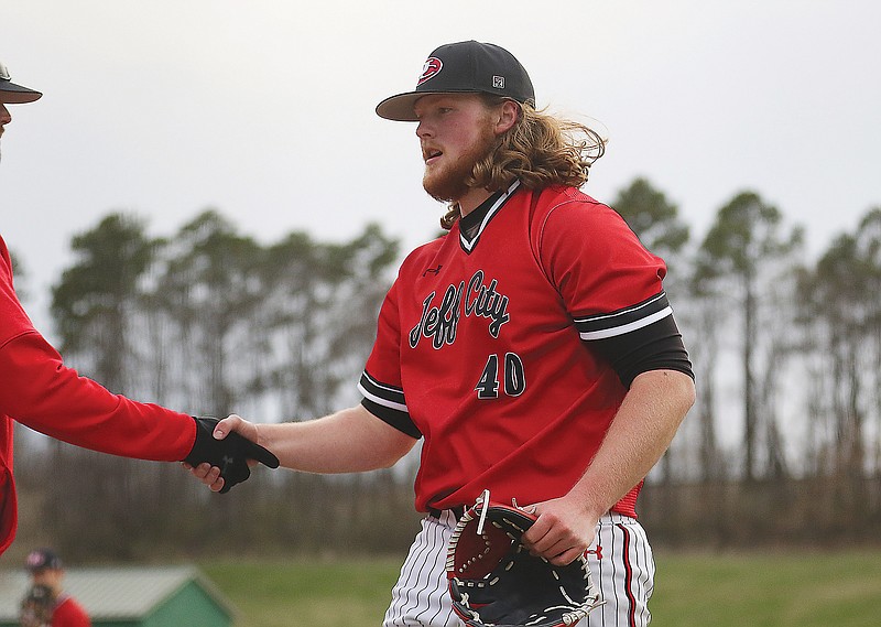 Jefferson City starting pitcher Jacob Roettgen shakes hands with coach Kyle Lasley while coming off the field during Wednesday's game against Blair Oaks at Vivion Field.