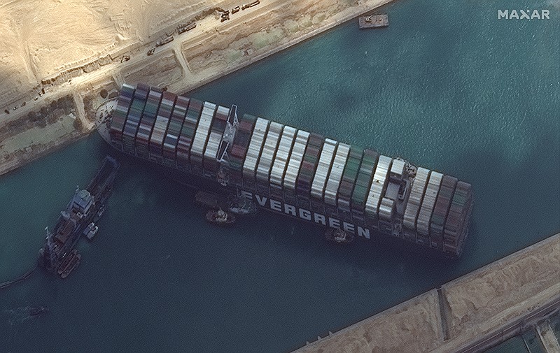 This satellite image from Maxar Technologies shows the cargo ship MV Ever Given stuck in the Suez Canal near Suez, Egypt, Friday, March 26, 2021. A maritime traffic jam grew to more than 200 vessels Friday outside the Suez Canal and some vessels began changing course as dredgers worked frantically to free a giant container ship that is stuck sideways in the waterway and disrupting global shipping. (©Maxar Technologies via AP)