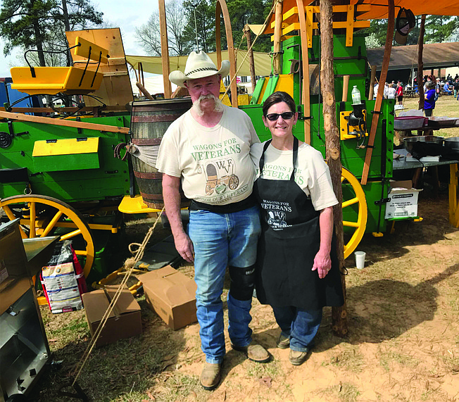 Local residents Jimmy and Connie Smith stand near their Old West-style chuckwagon during the recent third annual Wagons for Veterans fundraiser. The couple spent two years building the historically accurate wagon.