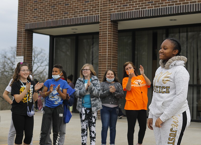 Liv Paggiarino/News TribunePeers clap and cheer Tuesday for Trinity Howard, right, as she receives first place in U.S. Cellular’s fifth annual Black History Art Contest in front of the Knowles YMCA. Trinity won the grand prize of $250 for her portrait of Rosa Parks.