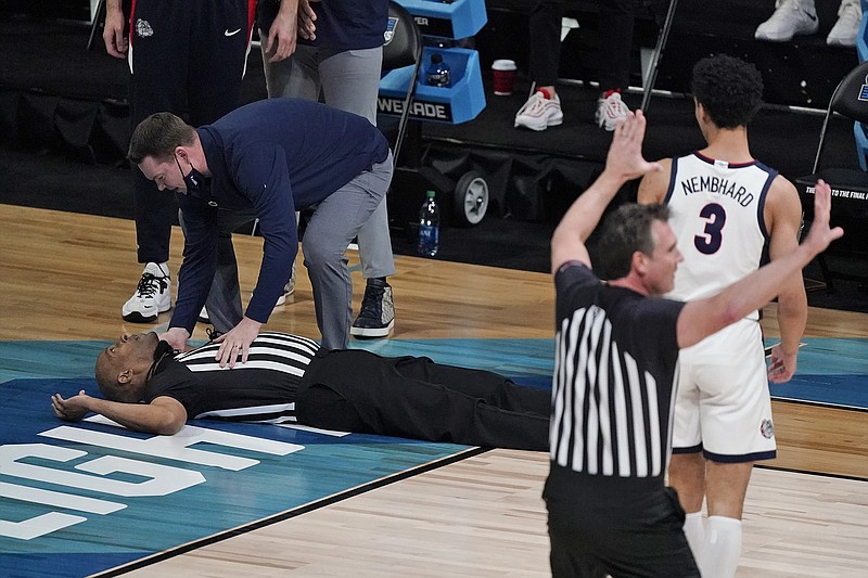 Referee Bert Smith collapses on the court during the first half of an Elite 8 game between Gonzaga and Southern California in the NCAA Tournament at Lucas Oil Stadium in Indianapolis.