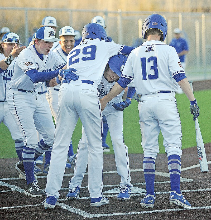 Taggert Bodenstab is mobbed by his Capital City teammates after hitting a grand slam in the bottom of the fifth inning of Monday's game against St. James at Capital City High School. It was the first home run in the history of the program.