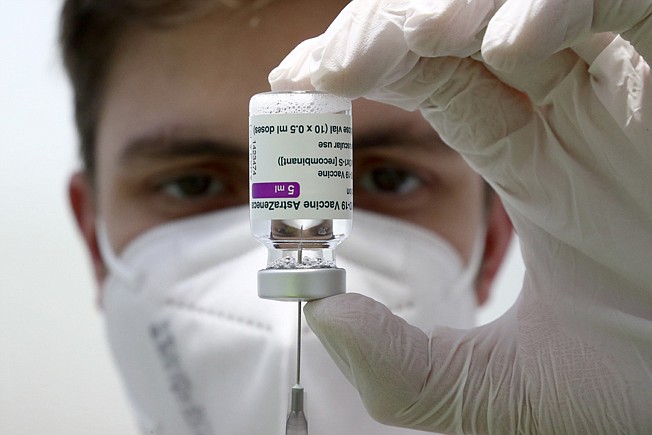 In this file photo dated Monday, March 22, 2021, medical staff prepares a syringe from a vial of the AstraZeneca coronavirus vaccine during preparations at the vaccine center in Ebersberg near Munich, Germany.  Berlin's top health official said Tuesday March 30, 2021, that the German state of Berlin is again suspending the use of AstraZeneca's coronavirus vaccine for people under 60 as a precaution, due to reports of blood clots. (AP Photo/Matthias Schrader, FILE)