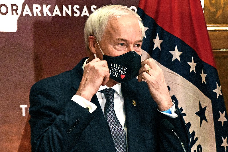 In this July 20, 2020 file photo, Arkansas Gov. Asa Hutchinson removes his mask before a briefing at the state capitol in Little Rock. Hutchinson has signed into law a measure that would allow doctors to refuse to treat someone because of moral or religious objections. Gov. Hutchinson on Friday, March 26, 2021, signed the legislation, despite objections that it would give medical providers broad powers to turn away LGBTQ patients and others. (Staci Vandagriff/The Arkansas Democrat-Gazette via AP, File)