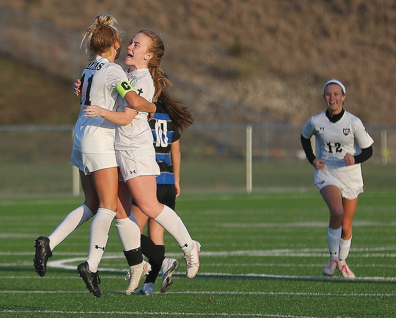 Helias teammates Izzy Luebbert (left) and Savanah Feltrop celebrate after Luebbert scored the first goal in Wednesday's game against Capital City at Capital City High School.