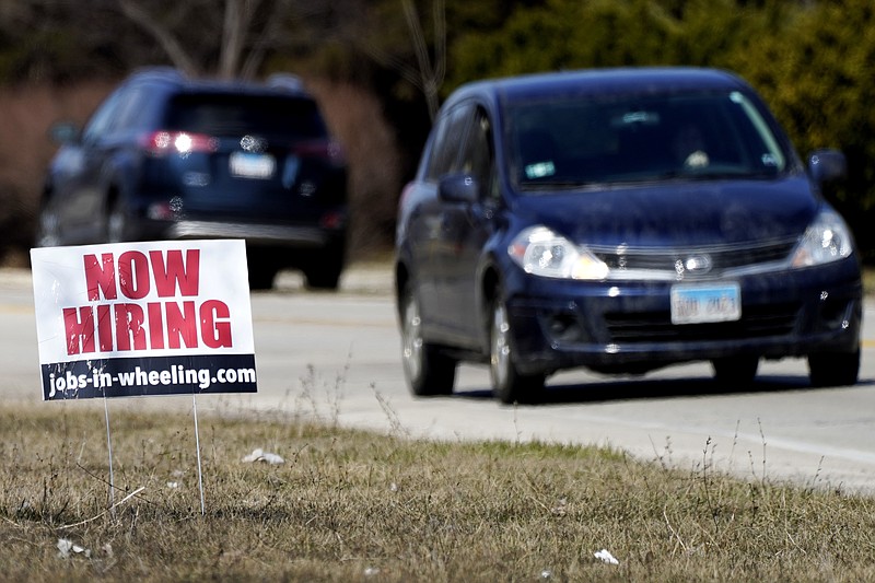 A hiring sign shows in Wheeling, Ill., Sunday, March 21, 2021.  America’s employers unleashed a burst of hiring in March, adding 916,000 jobs in a sign that a sustained recovery from the pandemic recession is taking hold as vaccinations accelerate, stimulus checks flow through the economy and businesses increasingly reopen.   (AP Photo/Nam Y. Huh)