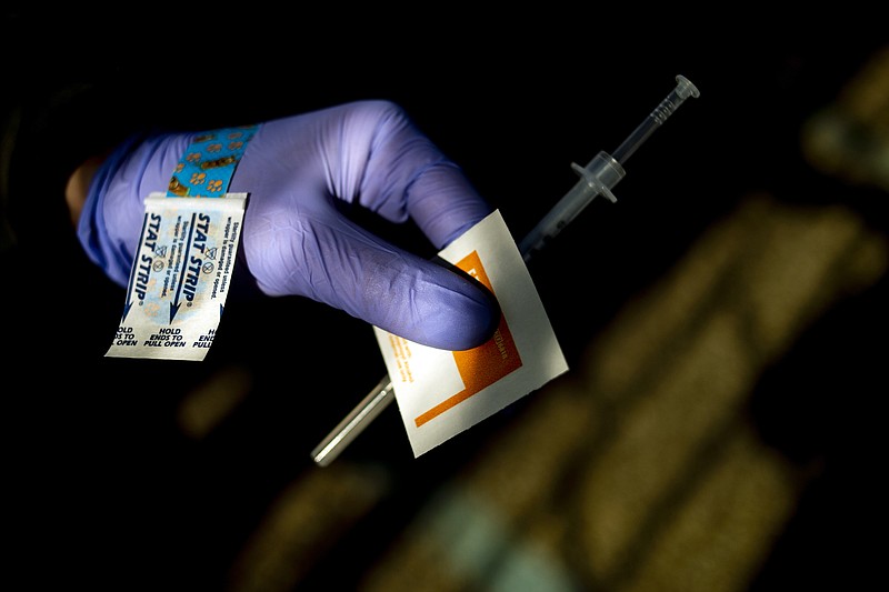 FILE - In this March 29, 2021, file photo, UM-Flint nursing student Michaela Dimello helps administer the first dose of the Moderna COVID-19 vaccine to Genesee County residents at Bishop Airport in Flint, Mich. A new poll from The Associated Press-NORC Center for Public Affairs Research shows that the percentage of Americans resisting getting inoculated has shrunk in the past few months. But it’s still not enough to pull America out of the pandemic, and reach herd immunity. (Jake May/The Flint Journal via AP, File)