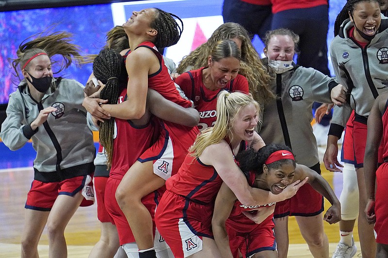 Arizona players celebrate Friday night after defeating UConn 69-59 in the semifinals of the NCAA Tournament at the Alamodome in San Antonio.