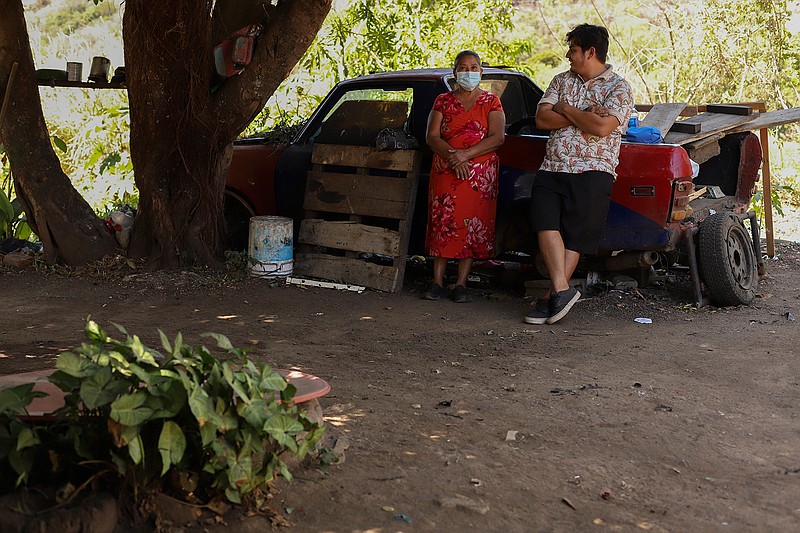 Elmer Peraza, right, talks to his grandmother Elsa Victorina Franco, Friday, March 5, 2021, in El Ranchador, Santa Ana, El Salvador. The family runs a bakery at home and delivers the bread on a bike. They live humbly but are in a better place thanks to financial support from a family member in the United States who is part of the Temporary Protected Status program. (AP Photo/Salvador Melendez)