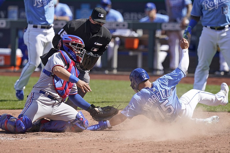 Whit Merrifield of the Royals beats the tag by Rangers catcher Jose Trevino to score a run during the sixth inning of Saturday afternoon's game at Kauffman Stadium.