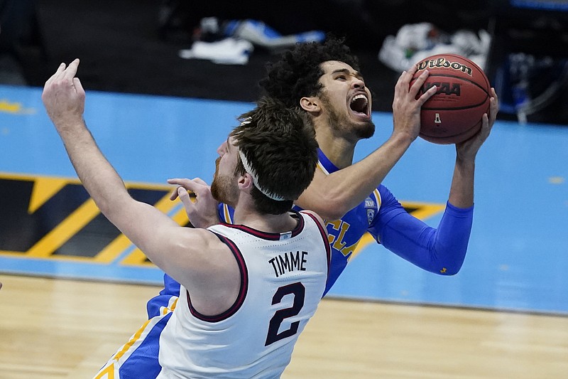 Johnny Juzang of UCLA is called for a charge against Drew Timme of Gonzaga late in regulation Saturday night in the NCAA Tournament semifinal at Lucas Oil Stadium in Indianapolis.