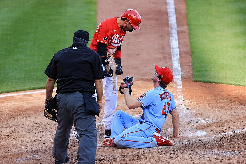 Cincinnati Reds' Nick Castellanos, center, reacts after scoring a run ahead of the tag by St. Louis Cardinals' Jake Woodford, right, during the fourth inning of a baseball game in Cincinnati, Saturday, April 3, 2021. (AP Photo/Aaron Doster)