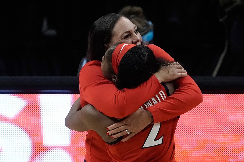 Arizona head coach Adia Barnes gets a hug from guard Aari McDonald (2) at the end of a women's Final Four NCAA college basketball tournament semifinal game against Connecticut Friday, April 2, 2021, at the Alamodome in San Antonio. Arizona won 69-59. (AP Photo/Morry Gash)