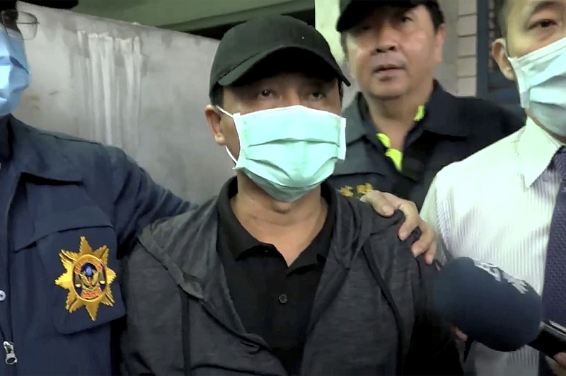 In this image taken from video, Lee Yi-hsiang, the driver of the truck that caused the train accident on Saturday, offers a public apology as he is led by police Sunday, April 4, 2021, in Hualien, Taiwan. Lee's truck slid into the path of an oncoming train, causing Taiwan's worst railway accident in decades that which killed dozens of people, and injuring hundreds more. (EBC via AP)