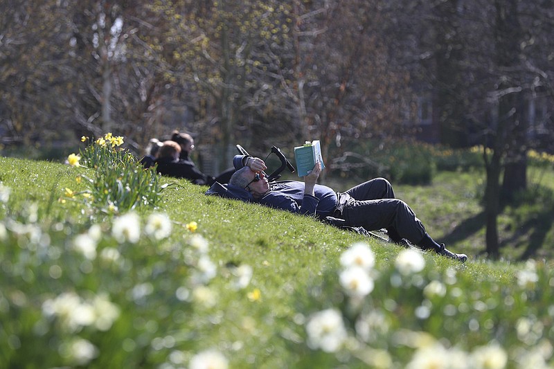 People enjoy the sunny weather in Sefton Park in Liverpool, England, Sunday April 4, 2021.  During current coronavirus restrictions people are allowed to meet up and exercise in the open air. (Peter Byrne/PA via AP)