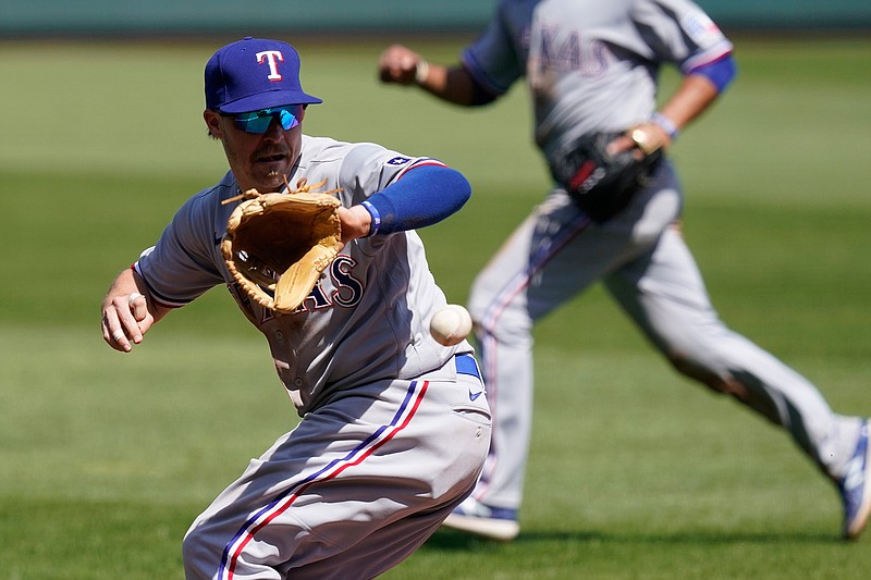 Texas Rangers third baseman Brock Holt fields a ball hit during the fourth inning Sunday at Kauffman Stadium in Kansas City, Mo. 