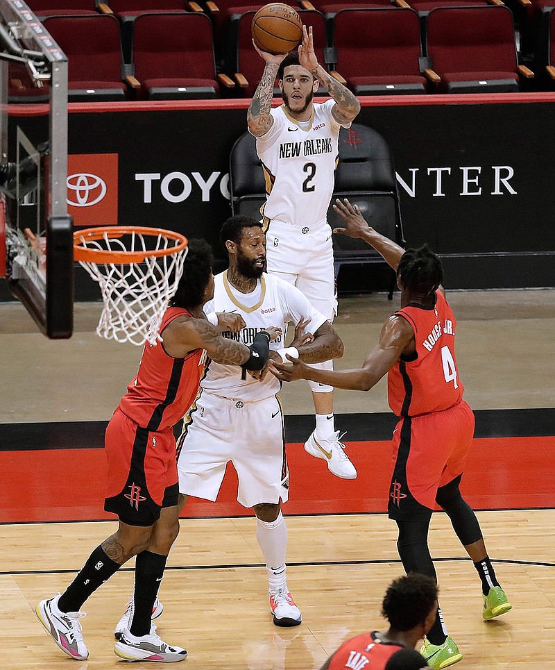 New Orleans Pelicans' Lonzo Ball (2) shoots a 3-pointer over Houston Rockets' Danuel House Jr. (4) during the first quarter of an NBA basketball game Sunday, April 4, 2021, in Houston. (Bob Levey/Pool Photo via AP)